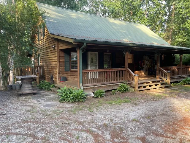 a front view of a house with porch and furniture