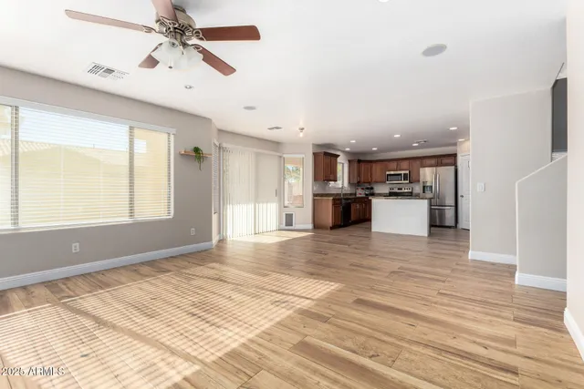 a view of kitchen with stainless steel appliances kitchen island granite countertop a refrigerator stove top oven and sink