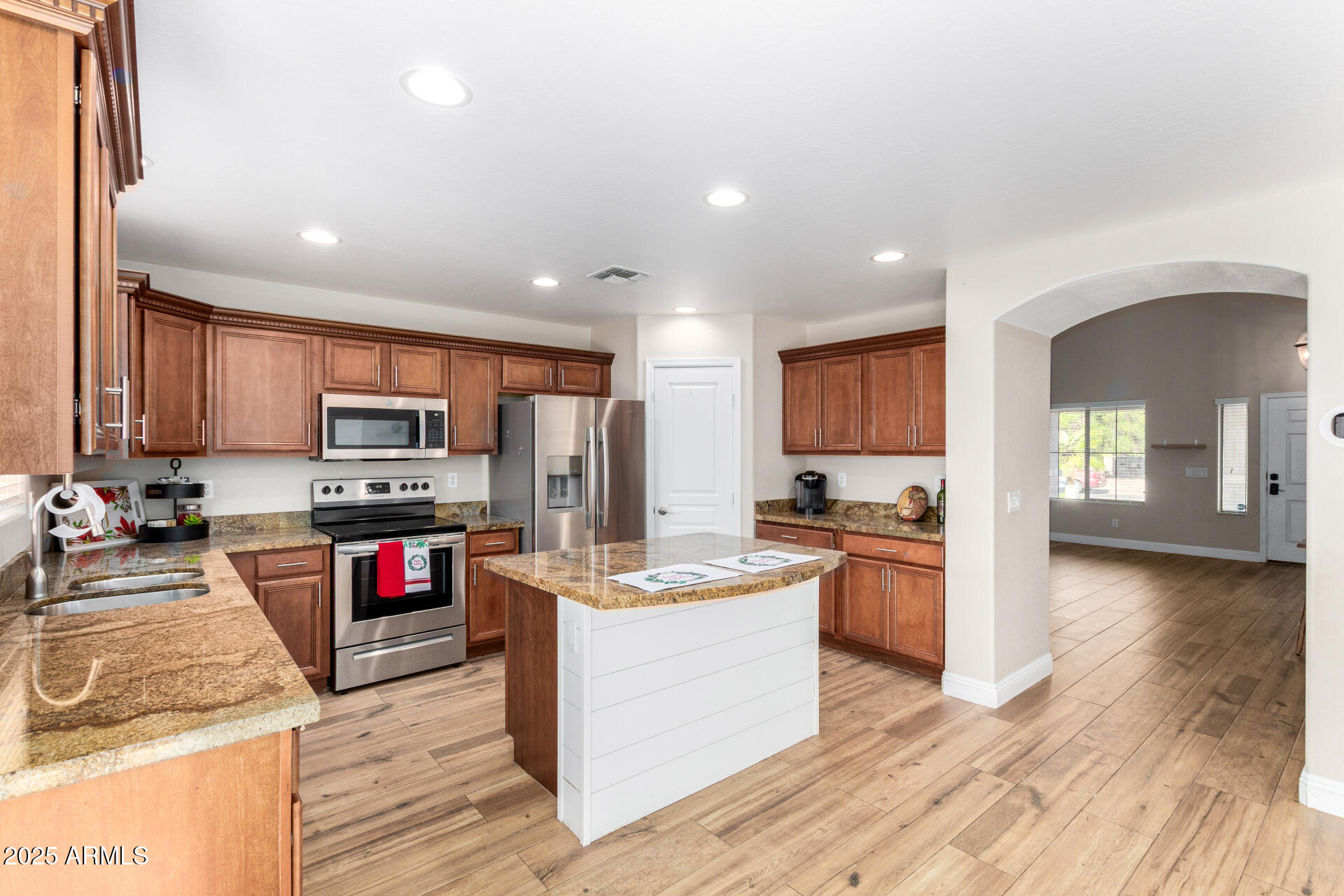 3563 East Blue Ridge Way Gilbert, AZ 85298 - Photo 16 of 48 a kitchen with stainless steel appliances granite countertop a stove top oven a sink dishwasher and a refrigerator with wooden floor