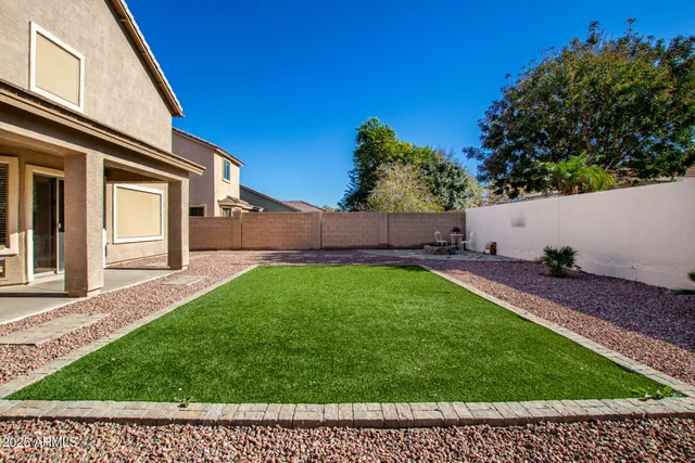 a view of backyard with potted plants and wooden fence