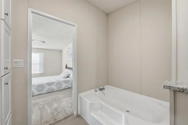 a bathroom with a tub sink and mirror