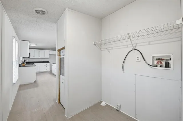 a view of a kitchen with refrigerator and white cabinets