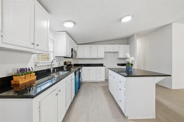 a kitchen with granite countertop a sink and cabinets