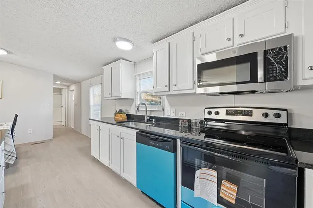 a kitchen with stainless steel appliances a stove a microwave sink and cabinets