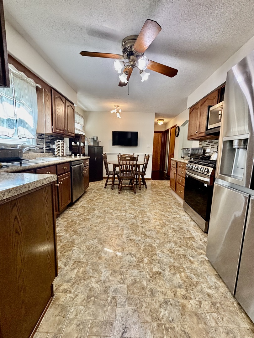 6737 104th Place Chicago Ridge, IL 60415 - Photo 19 of 32 a large kitchen with cabinets table and chairs