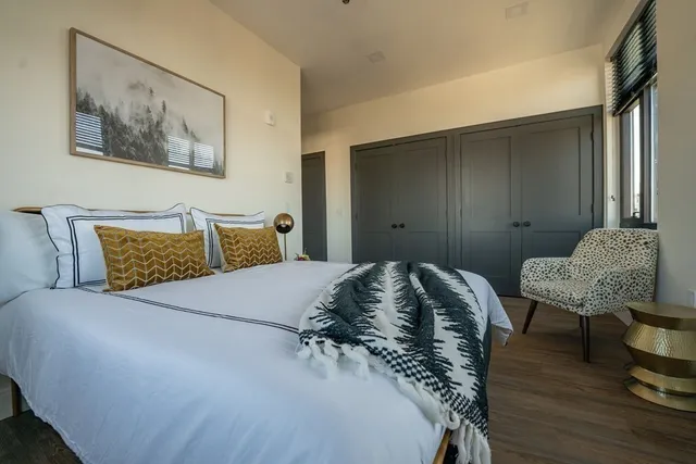 a bedroom with a bed and wooden floor