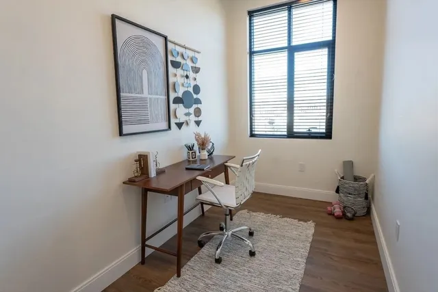 a view of a workspace with furniture and a window