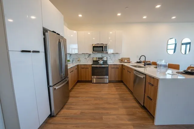 a large kitchen with stainless steel appliances lots of counter space and a sink