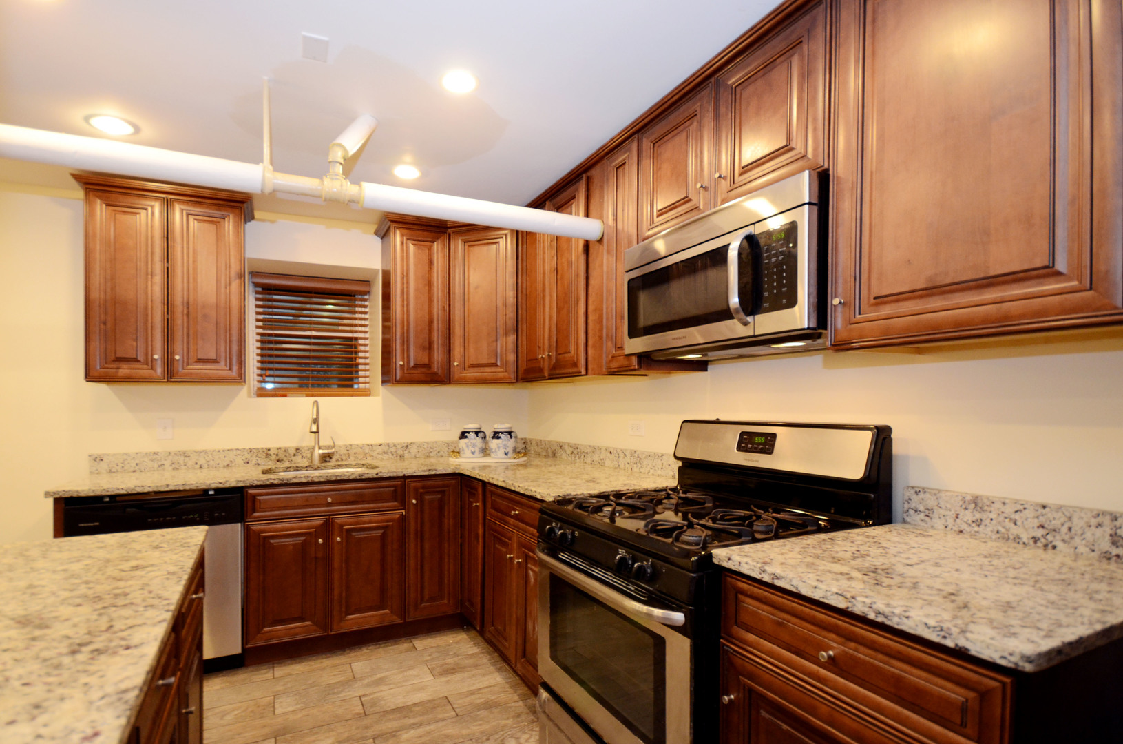 622 West Briar Place, Unit G Chicago, IL 60657 - Photo 4 of 19 a kitchen with stainless steel appliances granite countertop a stove and a microwave