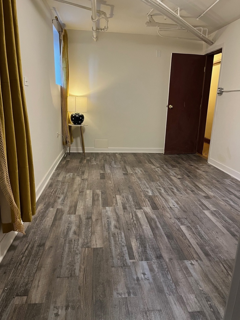 622 West Briar Place, Unit G Chicago, IL 60657 - Photo 10 of 19 a view of an empty room with wooden floor and a window