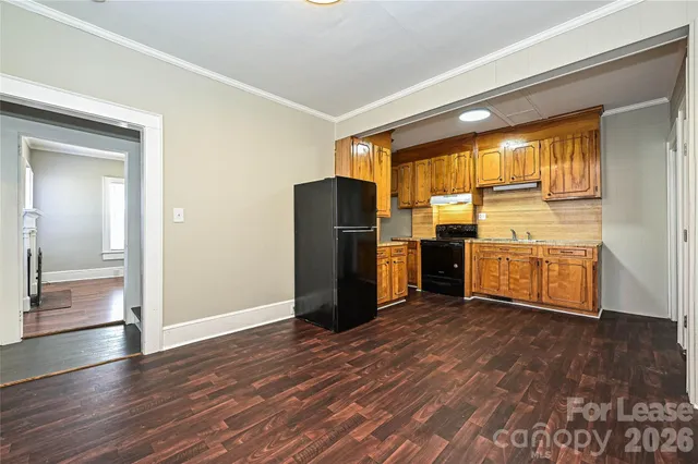 a view of a kitchen with wooden floor and electronic appliances