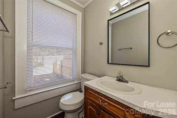 a bathroom with a granite countertop sink toilet a mirror and shower