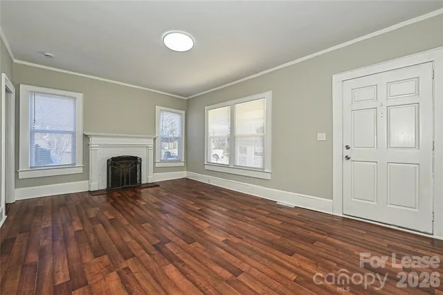 wooden floor fireplace and windows in an empty room