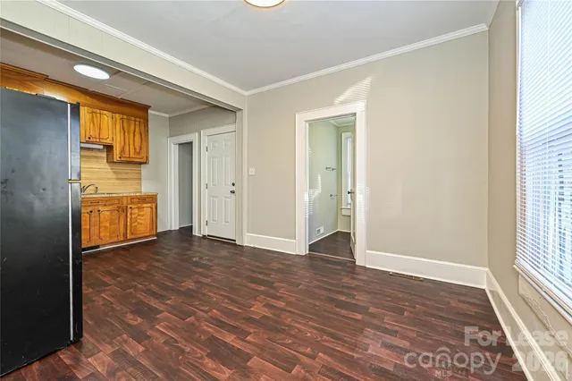 an empty room with windows and cabinet