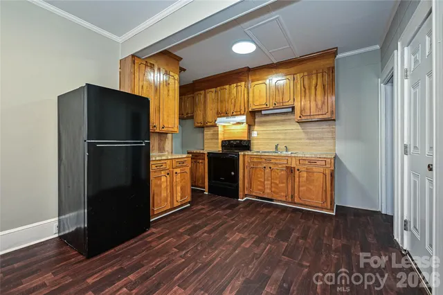 a kitchen with stainless steel appliances granite countertop a refrigerator a sink and wooden cabinets