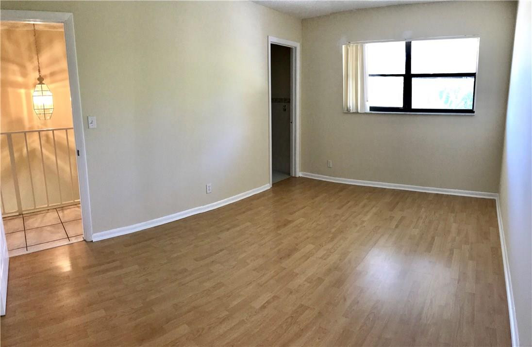 22435 Southwest 61st Way, Unit B124 Boca Raton, FL 33428 - Photo 22 of 35 an empty room with wooden floor and windows