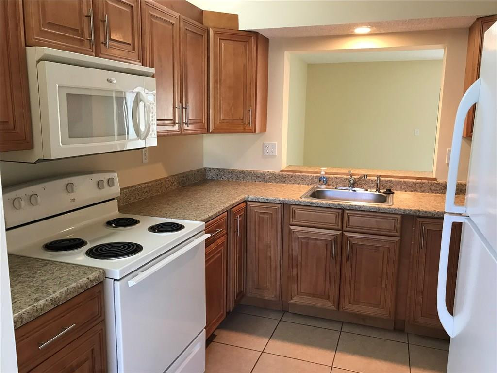 22435 Southwest 61st Way, Unit B124 Boca Raton, FL 33428 - Photo 4 of 35 a kitchen with cabinets and appliances