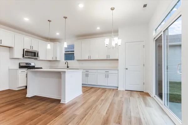 a large kitchen with cabinets wooden floor and stainless steel appliances