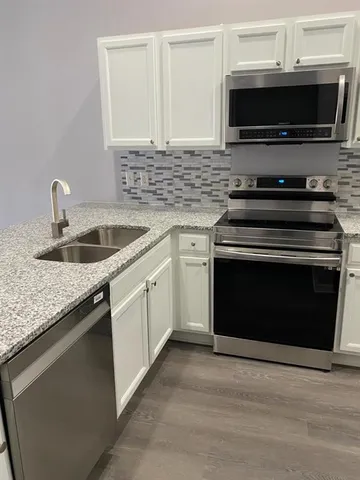 a kitchen with granite countertop a stove and a sink