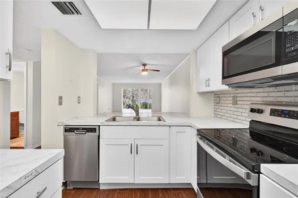 a kitchen with stainless steel appliances granite countertop a sink stove and microwave