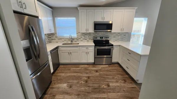 a kitchen with stainless steel appliances a refrigerator stove microwave and sink