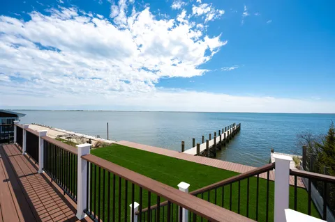 a front view of a house with yard and lake view