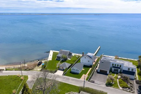 an aerial view of a city with lots of residential buildings ocean and mountain view in back