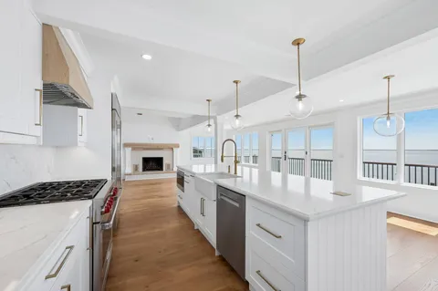 a kitchen with granite countertop a sink and white cabinets