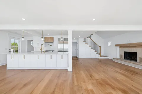a view of a kitchen with wooden floor and electronic appliances