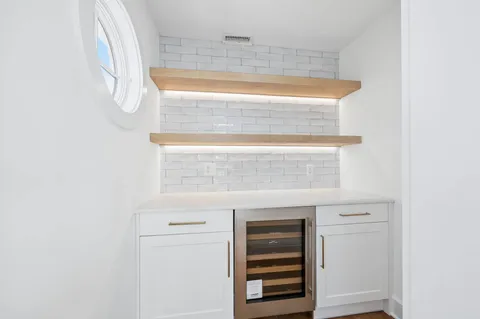 a kitchen with stainless steel appliances a stove top oven a sink a dining table and chairs