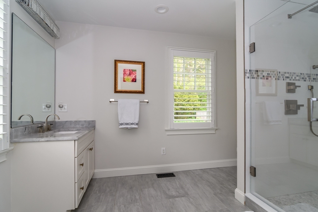 1098 Webster Street Needham, MA 02492 - Photo 16 of 21 a spacious bathroom with a granite countertop sink a mirror and shower