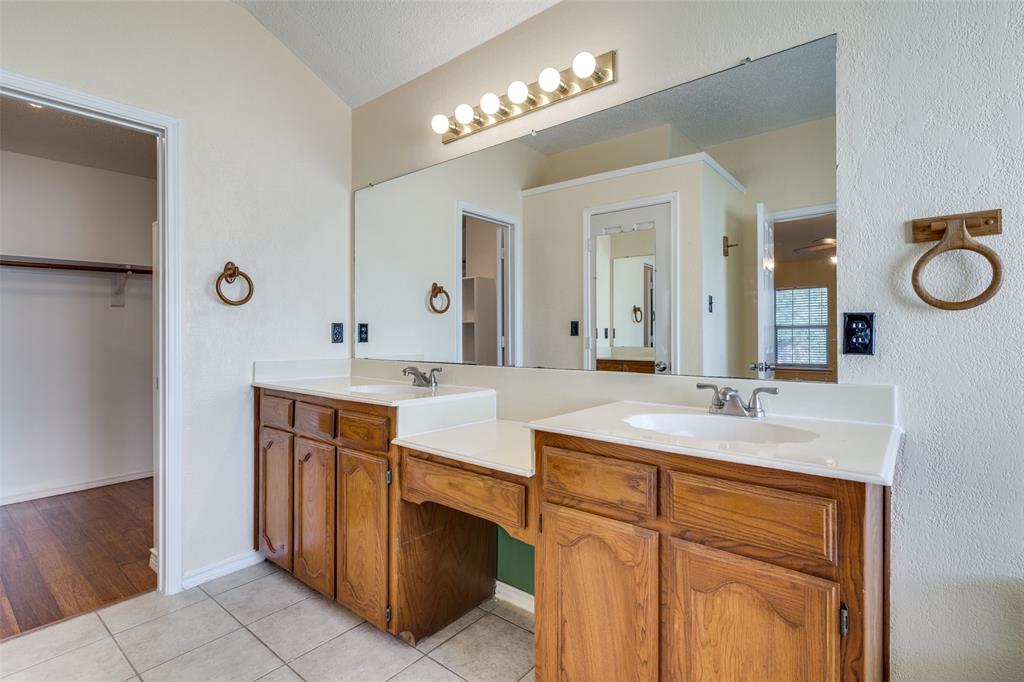 8305 Camden Court Rowlett, TX 75089 - Photo 12 of 18 Bathroom with double vanity, a walk in closet, and light tile patterned floors