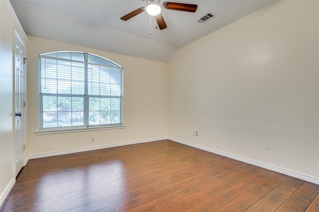 8305 Camden Court Rowlett, TX 75089 - Photo 14 of 18 Unfurnished room with dark wood-type flooring, vaulted ceiling, and a ceiling fan