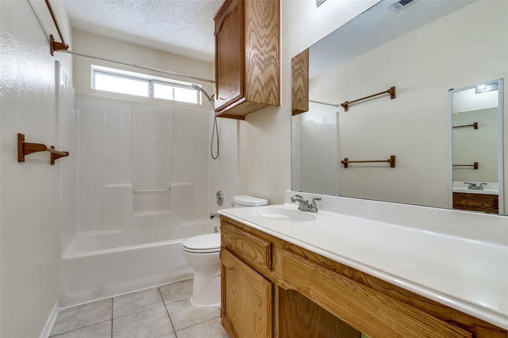 8305 Camden Court Rowlett, TX 75089 - Photo 16 of 18 Bathroom with washtub / shower combination, vanity, a textured ceiling, and light tile patterned flooring