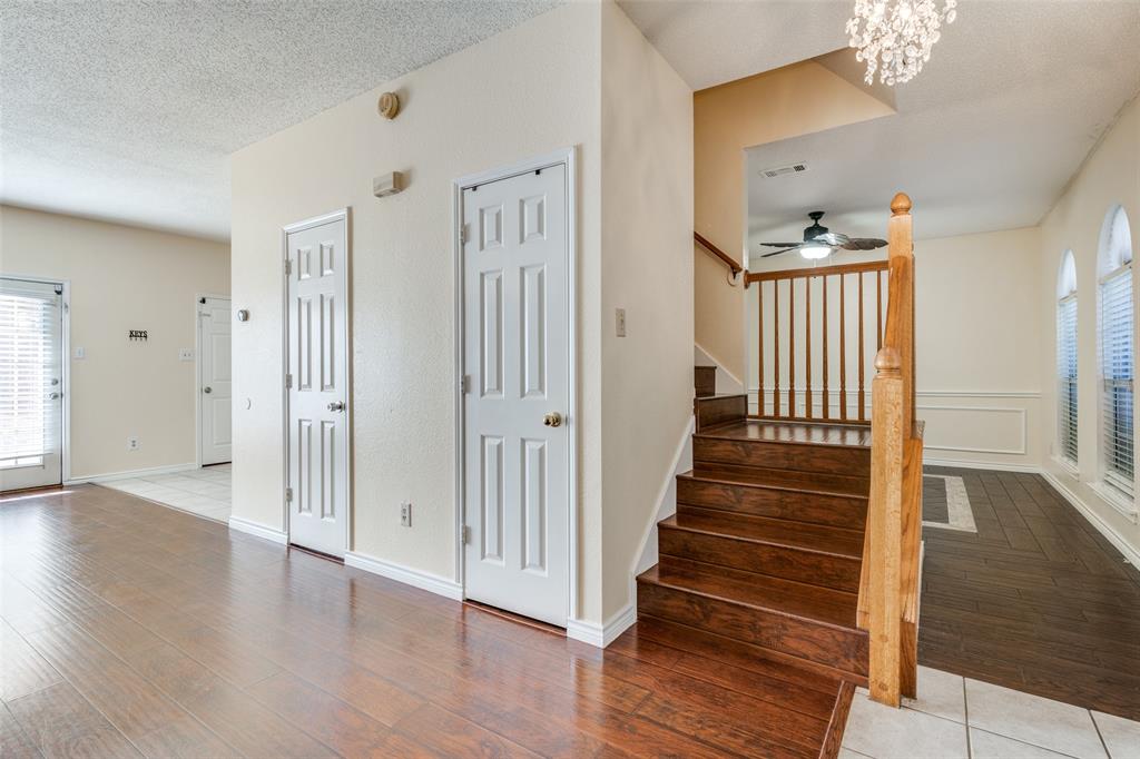 8305 Camden Court Rowlett, TX 75089 - Photo 9 of 18 Staircase with wood finished floors, a chandelier, a textured ceiling, and ceiling fan