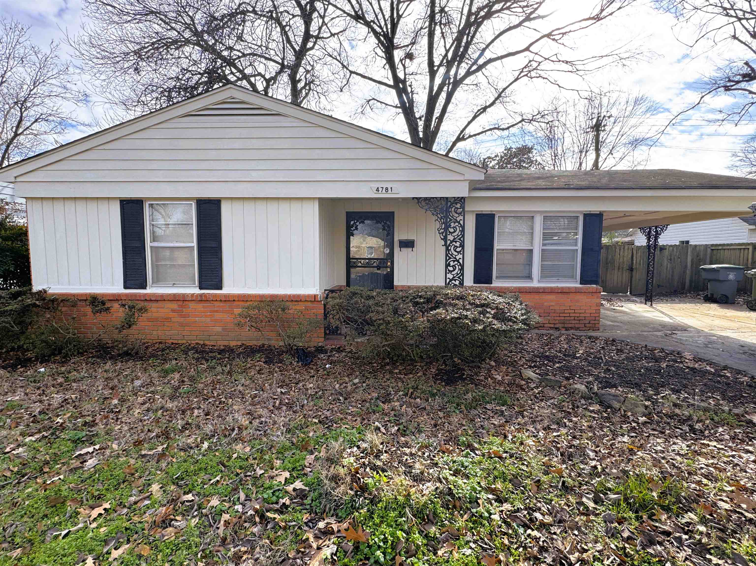 Bungalow-style house featuring brick siding, an attached carport, and a porch