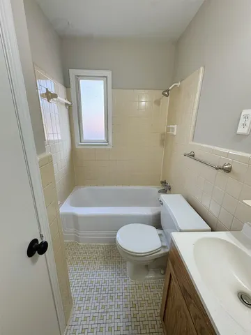 a bathroom with a sink a toilet a tub and shower