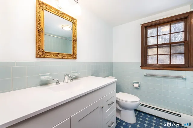a bathroom with a toilet sink and mirror