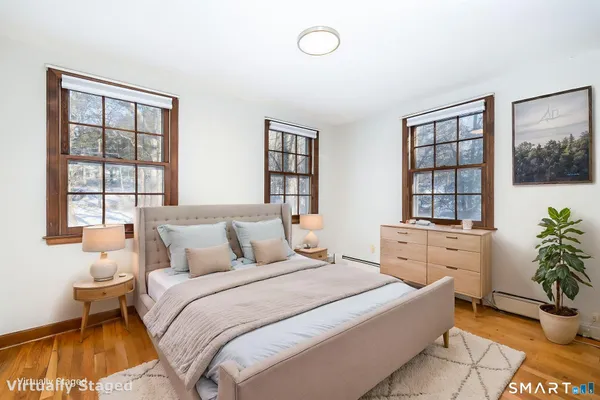 a bedroom with a bed and a large window