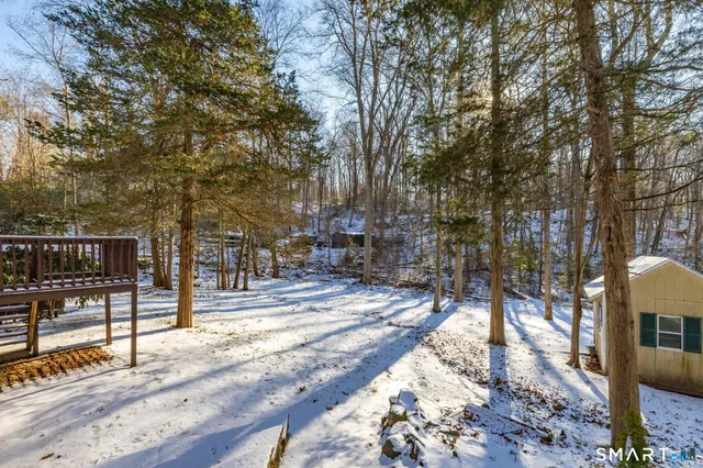 a view of a barn with a large tree and yard