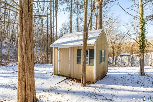 a view of house with a yard and a large tree