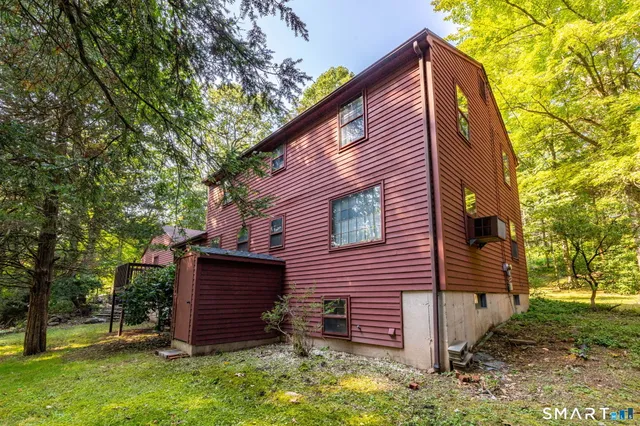 a view of a house with a large tree and a yard