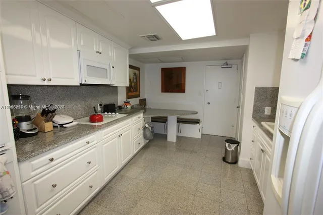 a kitchen with cabinets and white appliances