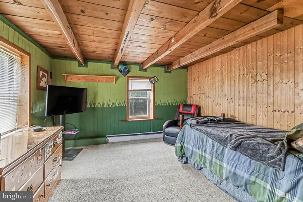 a bedroom with a bed a flat screen tv and a chandelier