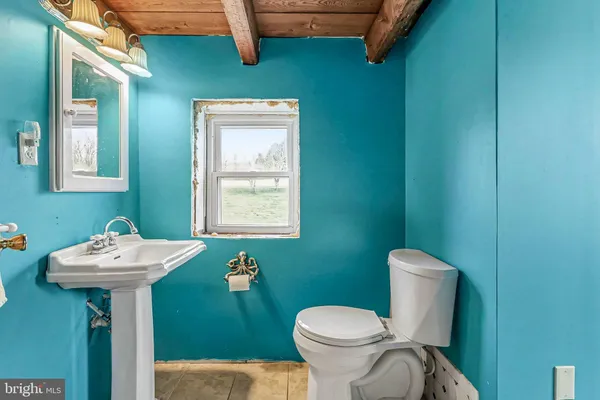 a bathroom with a sink mirror toilet and window