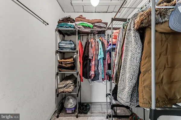 a view of walk in closet with clothes and shoes