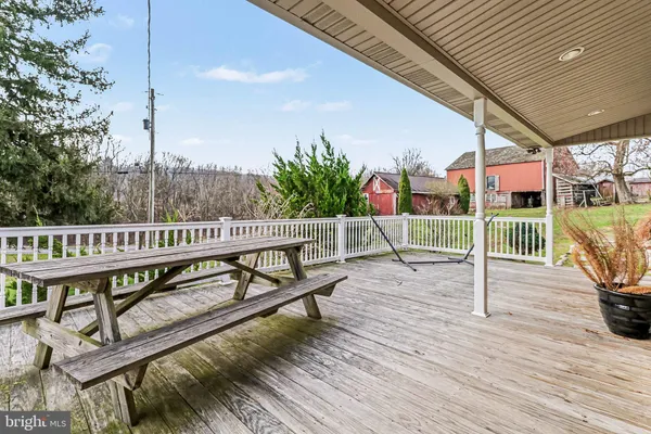a view of a roof deck with wooden fence and a bench