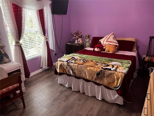 a bedroom with bed and wooden floor