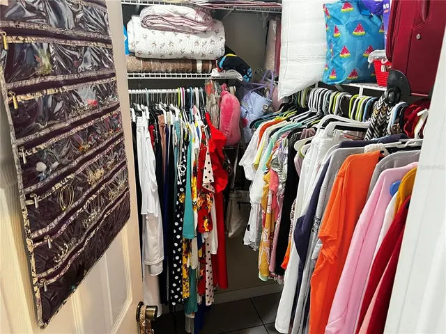 a view of walk in closet with clothes