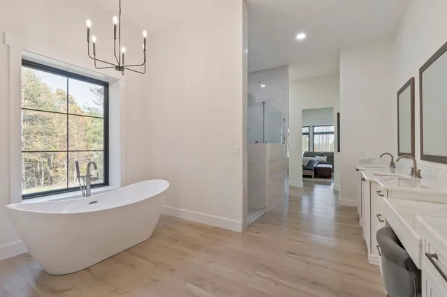 a spacious bedroom with a bed and a flat tv screen on dresser